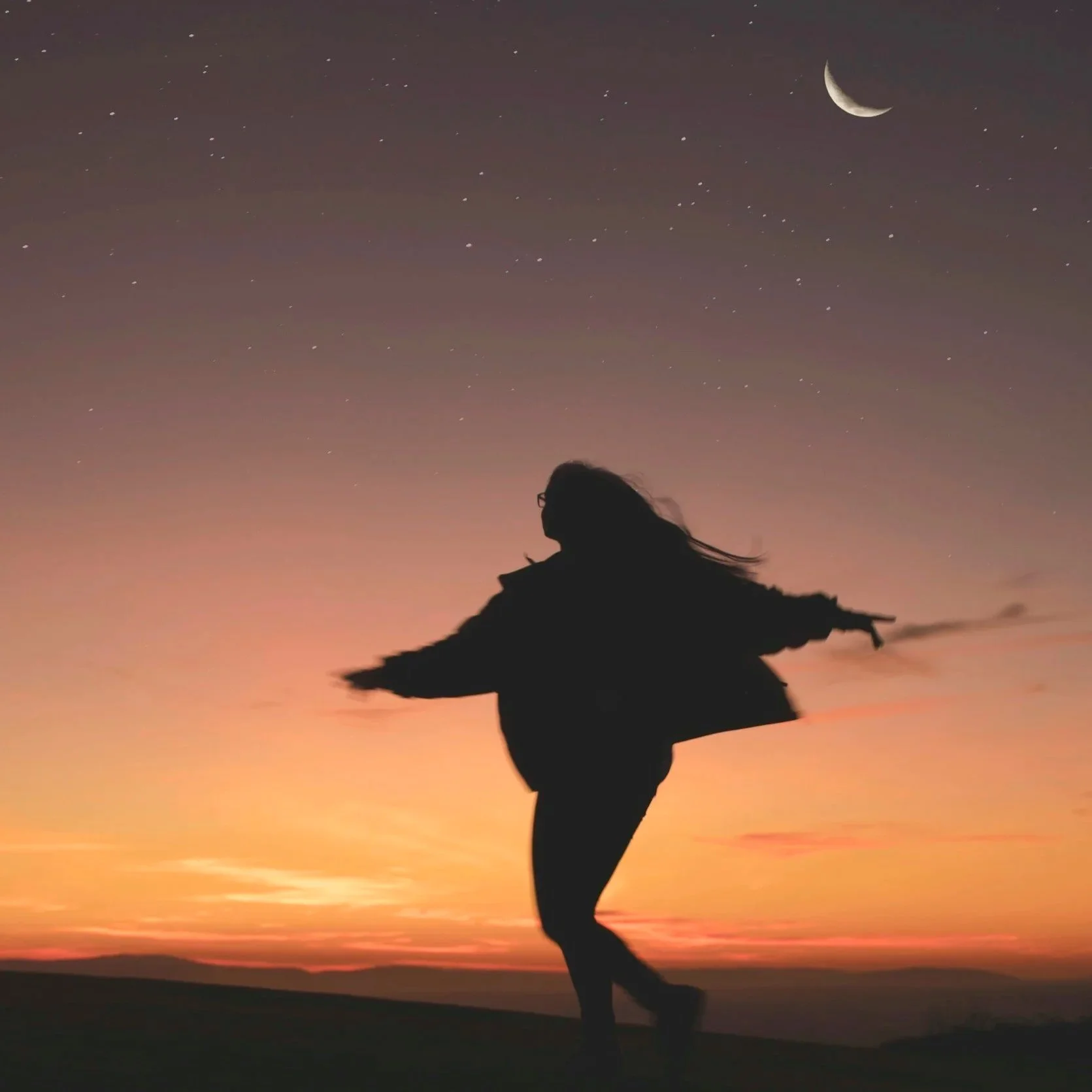 Woman dancing at sunset under the moon in a mystical way