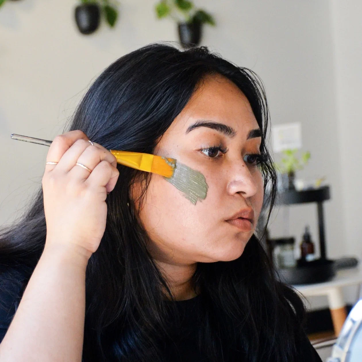 A woman putting a face mask on her face