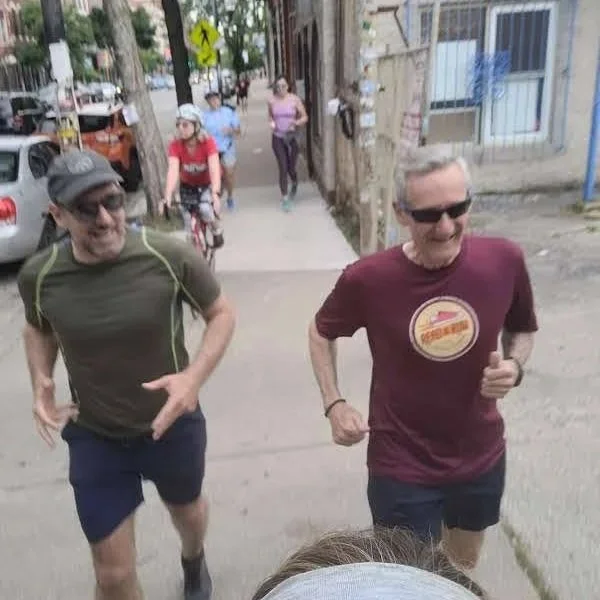 Two men running outside in the summer at a Read & Run Chicago event.
