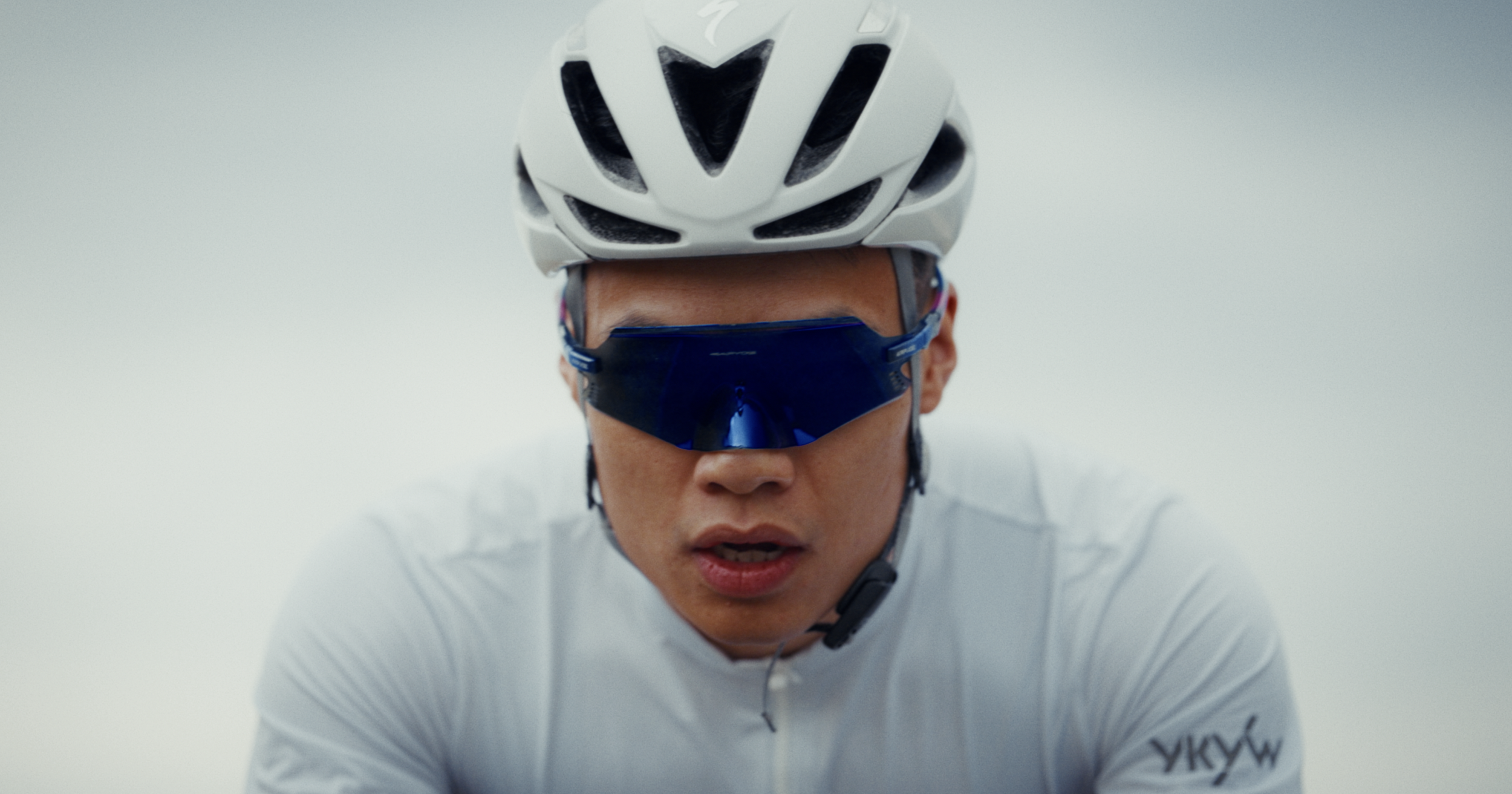 Portrait serré d'un cycliste, casque blanc et lunettes miroir