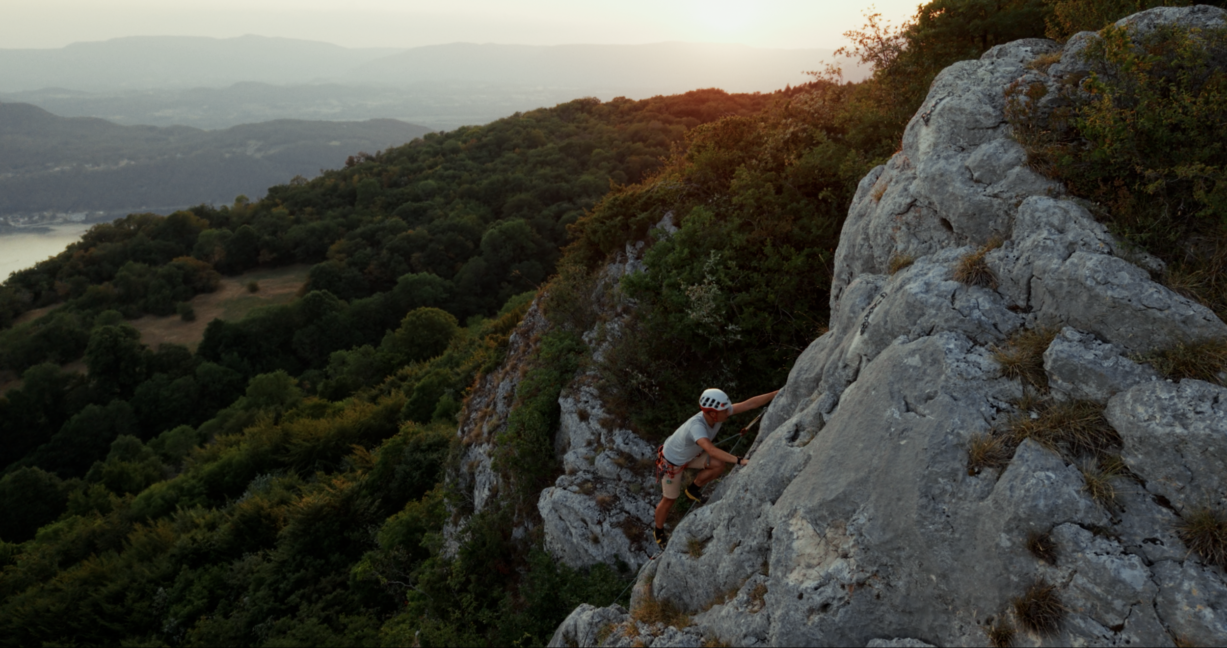 grimpeur sur sentier rocheux de montagne, paysage en contre-jour