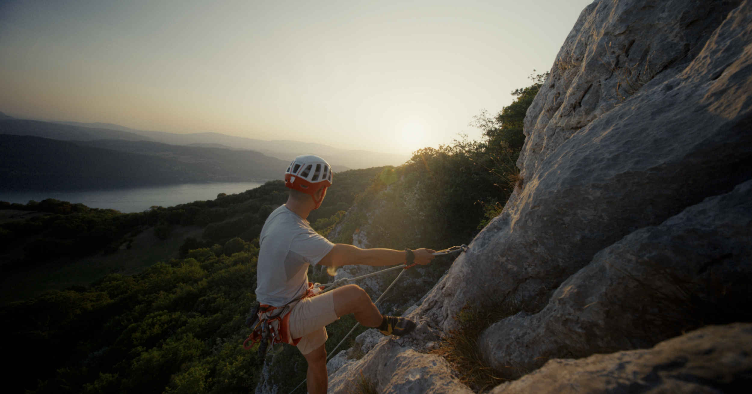 Sportif au repos sur des rochers au coucher du soleil — film Sony FX5