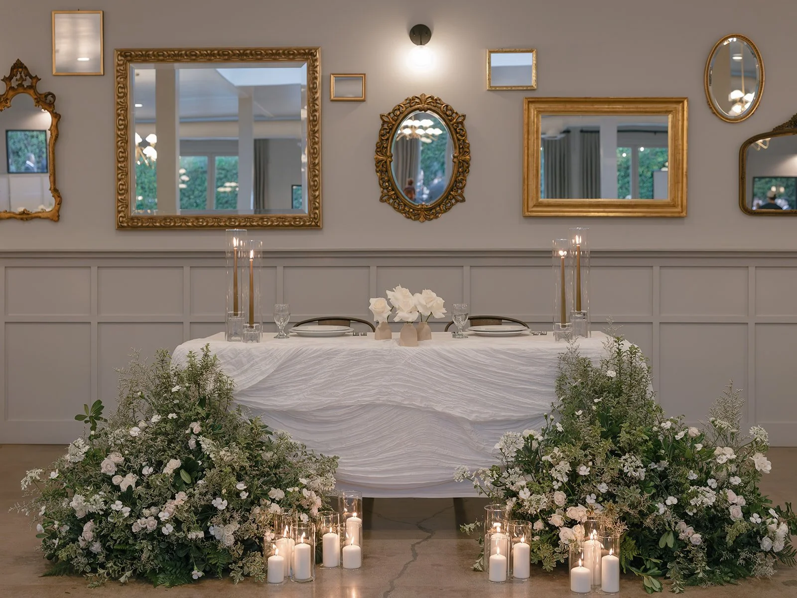 Reception table decor with white florals, candles, and textured linens