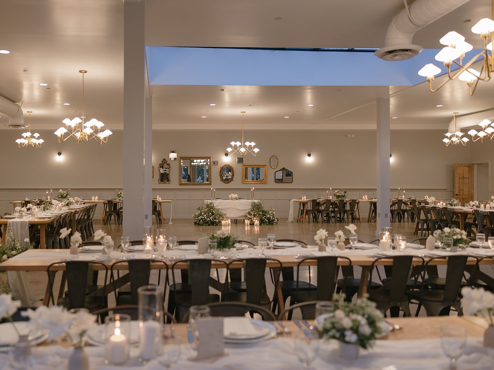 Reception room setup at The Harper with long tables, candles, and floral installations