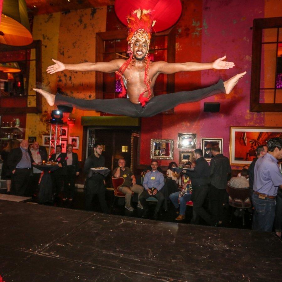 Shirtless performer leaping in front of audience members