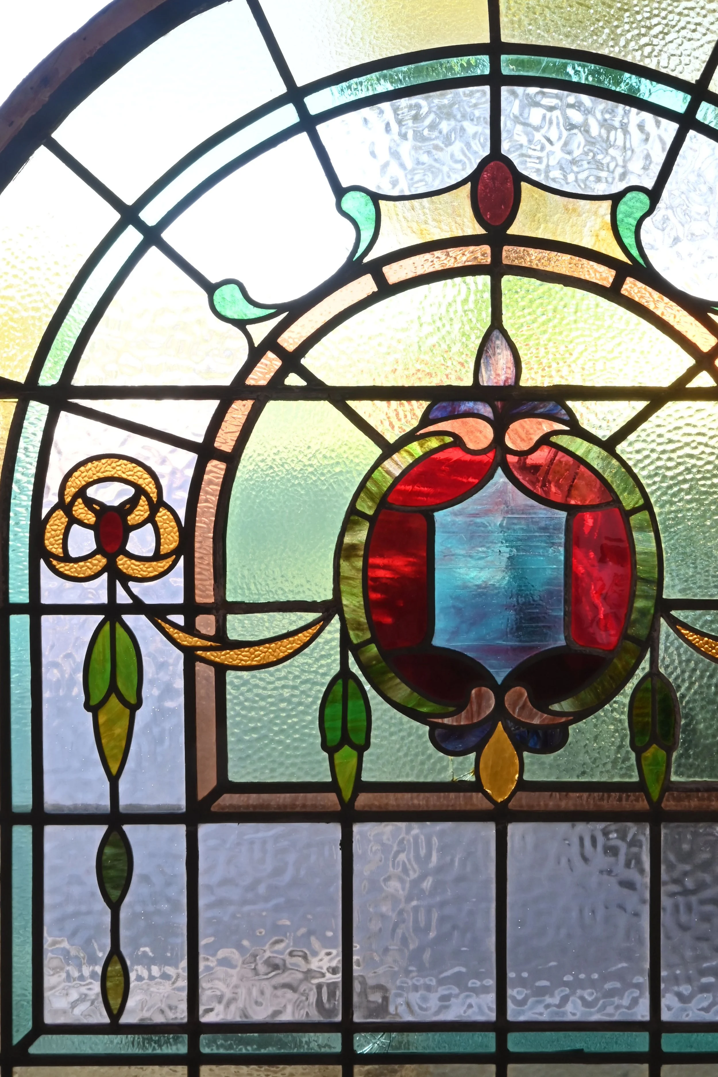 27673 large arched multicolored stained glass window with shield and garland 5.jpg