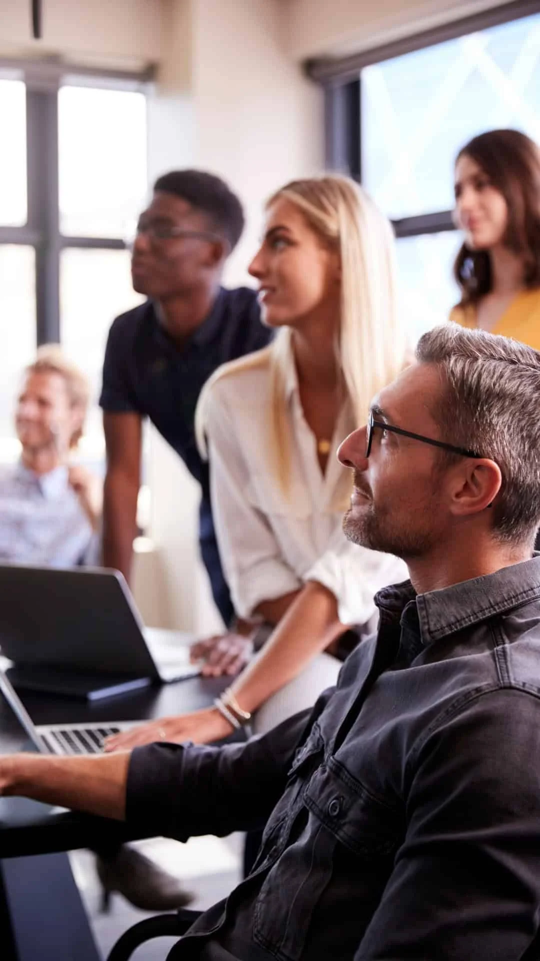 grupo de personas en una reunión de trabajo en una oficina moderna con mucha luz natural