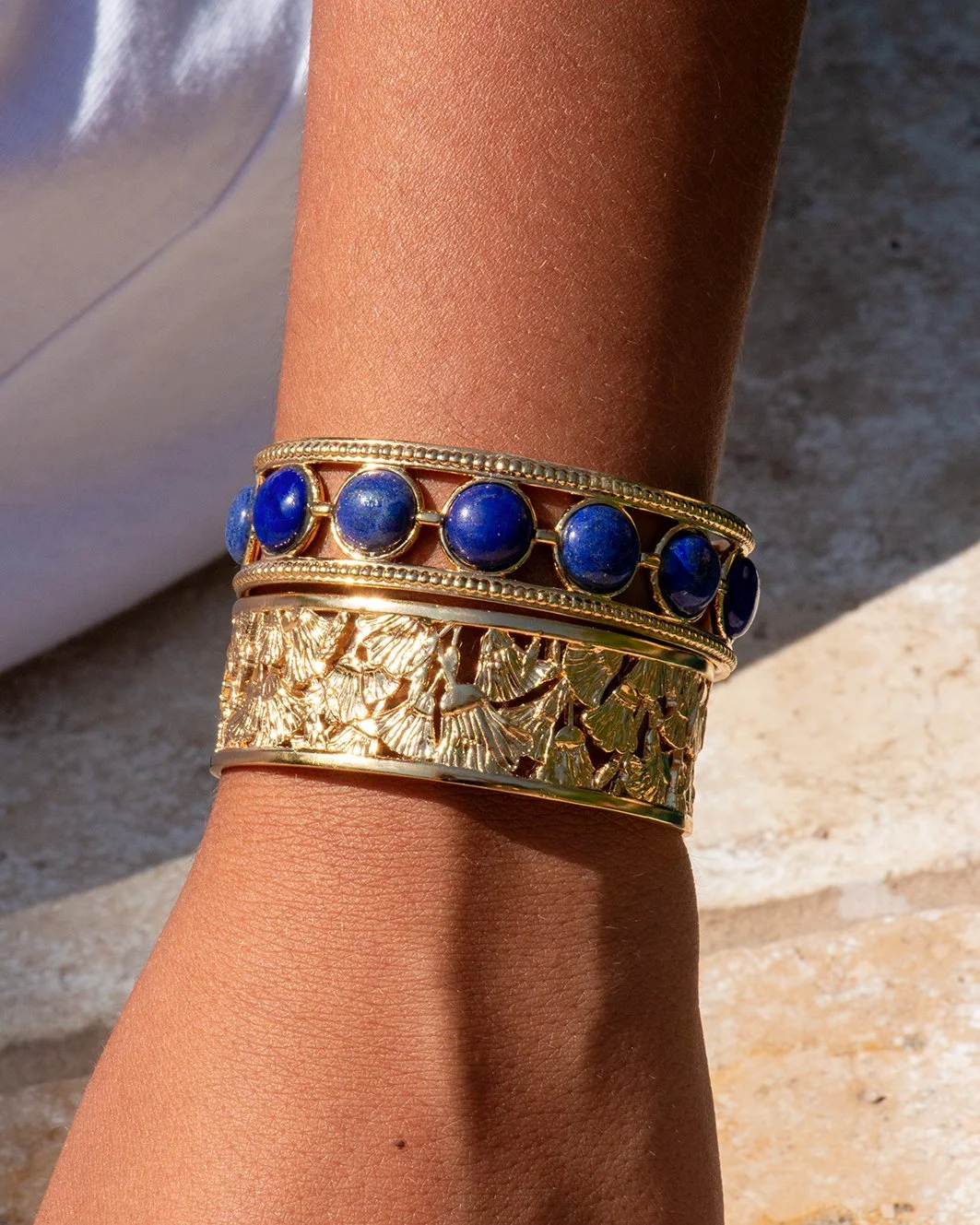Bracelet Nefertari en lapis-lazuli porté au poignet, bijou doré à l'or 18 carats d'inspiration égyptienne