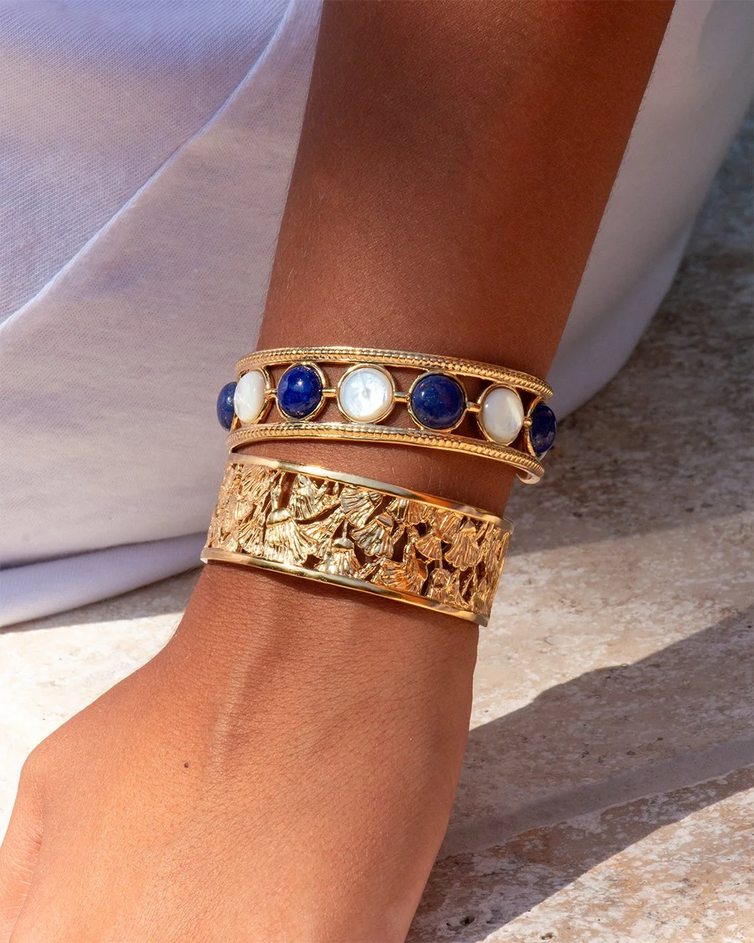 Gros plan sur le lapis-lazuli et la nacre naturelle positionnés à la main sur le bracelet jonc Nefertari Syracuse
