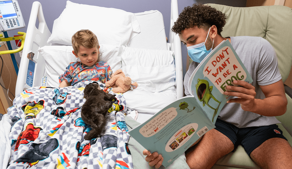  University of Wisconsin–Madison football player Nick Evers reads to Charlie as part of Book it With a Badger. 