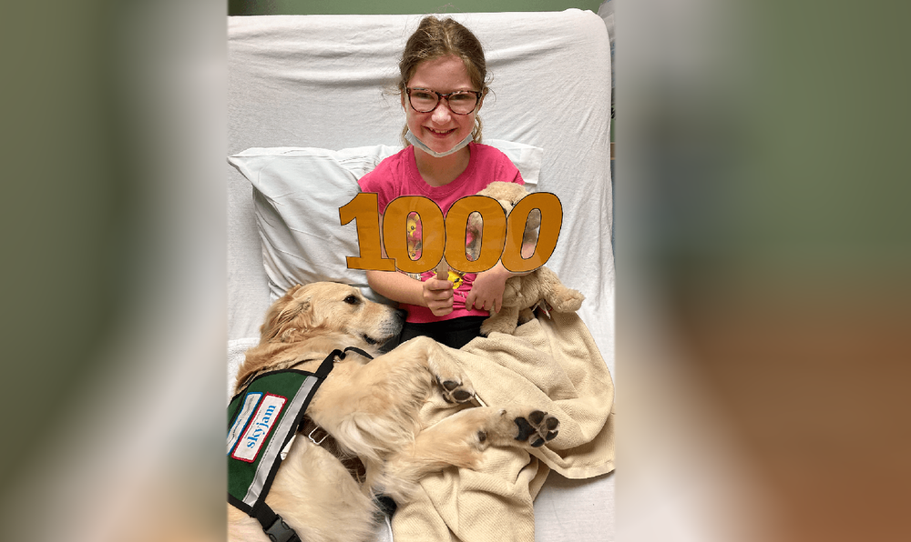  Sofia is excited to be Kiko’s 1,000th patient visit. Kiko is a specially trained facility dog and one of two four legged members of the Child Life staff. Kiko’s handler, Child Life Specialist Brianna Peterson, has been a part of Sofia’s care team si