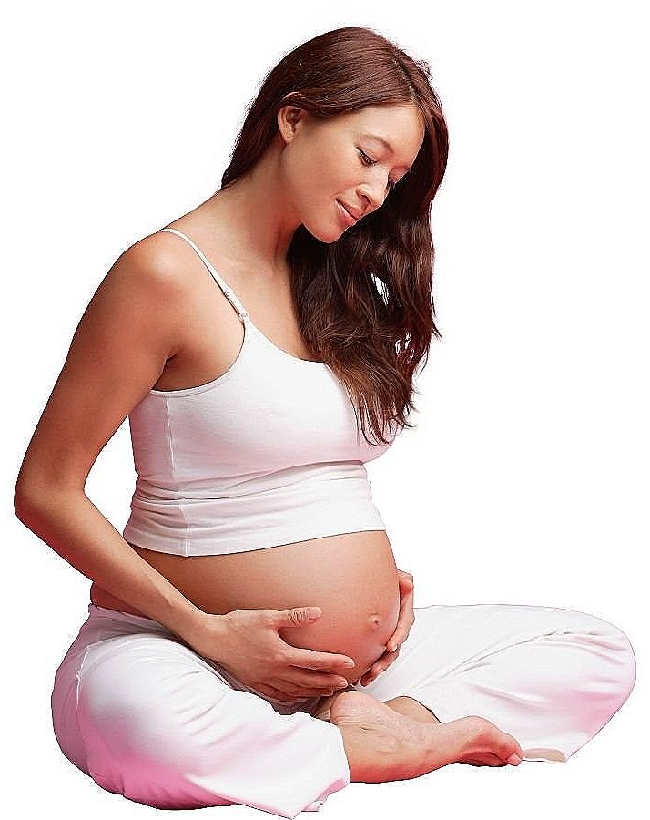 Pregnant woman sitting crossed legged, holding her belly.