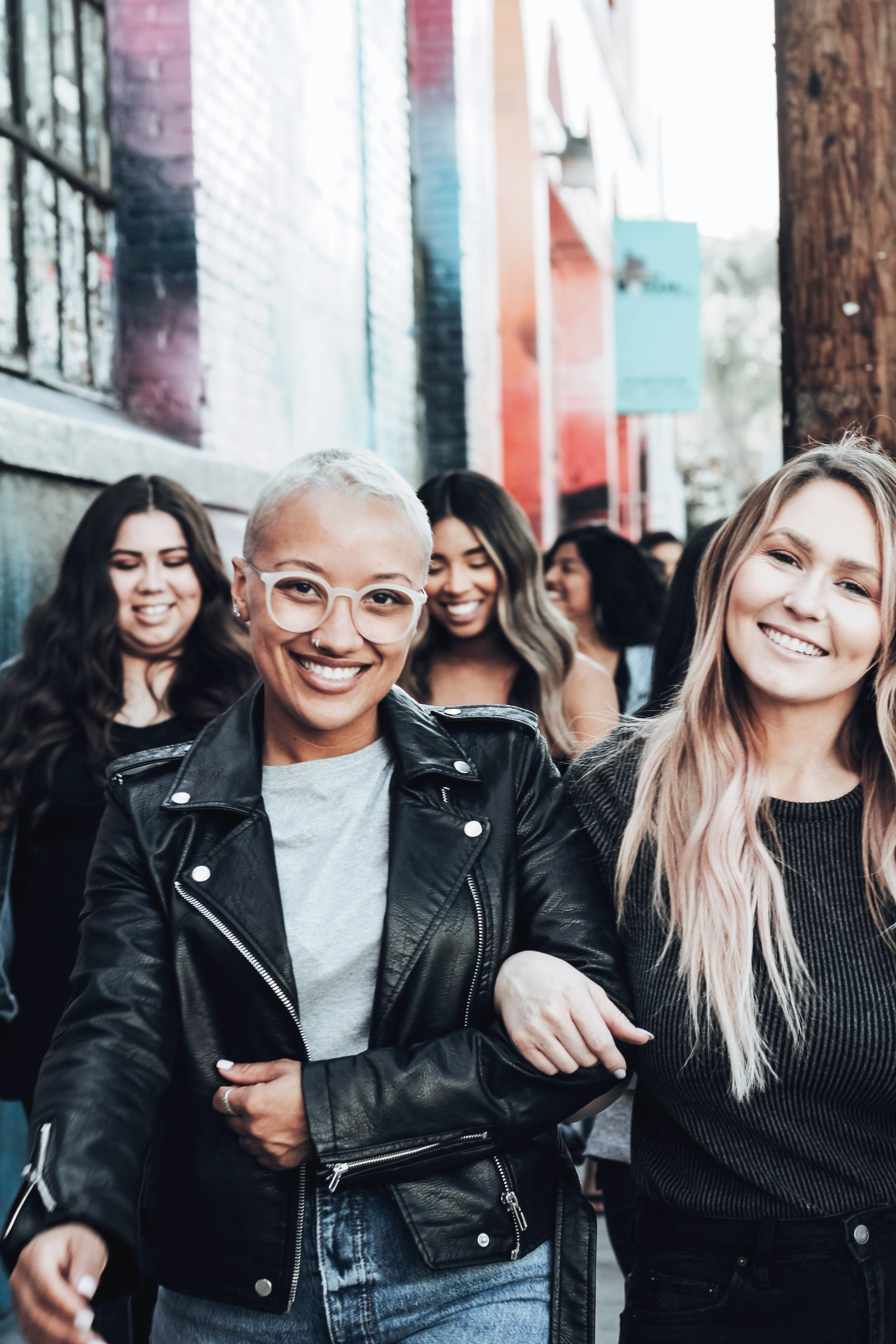 A group of five women walking down the street.
