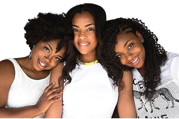 Three black women all smiling.