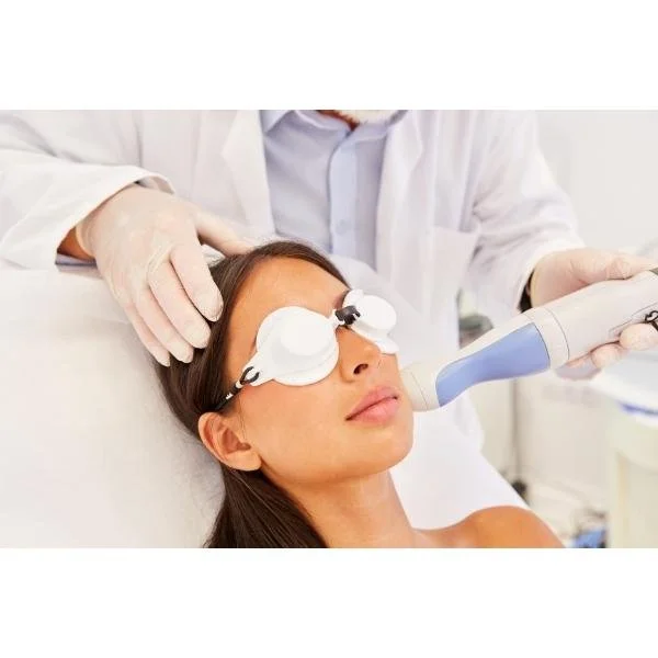 A woman wearing protective eyewear is getting laser skin resurfacing done on her face.