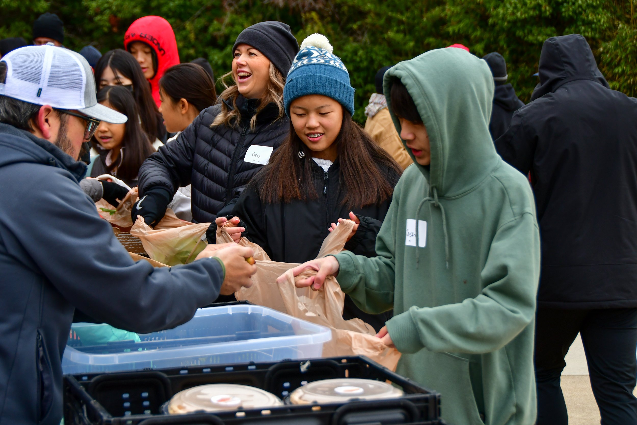 Volunteers assisting at packing table during a food distribution.