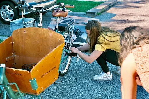 Kayla connecting Sweeping Beauty to the e-bike: Prince Clean-A-Lot