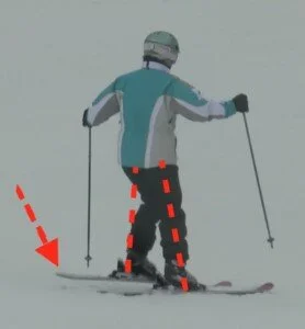In the middle of the turn, the skier releases the edge of the old outside ski. The skis: The edge is released by lifting the tail of the inside ski. The body: The left hip and knee flex to lift the left foot.