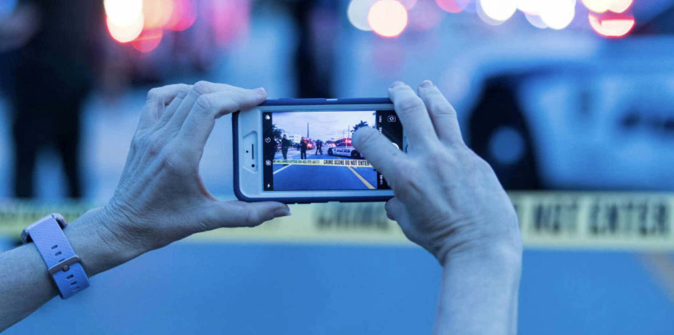 A person uses a mobile phone to photograph a crime scene