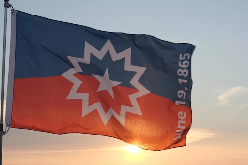 The Juneteenth flag featuring a red, white, and blue design with a central star burst and an arc representing a new horizon, symbolizing Black liberation and freedom in America.