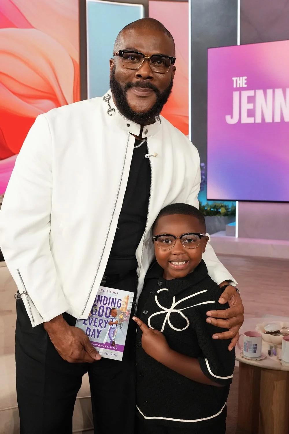Luke Tillman and Tyler Perry holding Finding God Every Day devotional book on the set of the Jennifer Hudson Show.