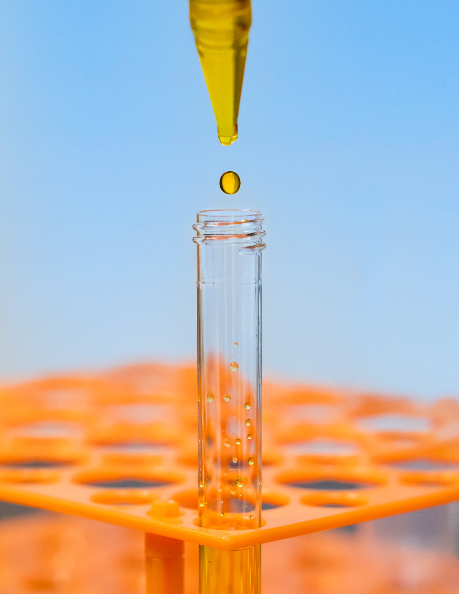 Drop of yellow liquid from pipette into test tube