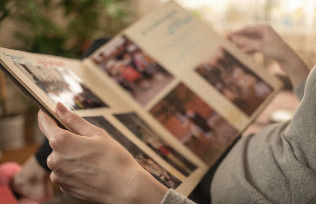 Man browsing through a photo album, reflecting on family traditions and heritage.