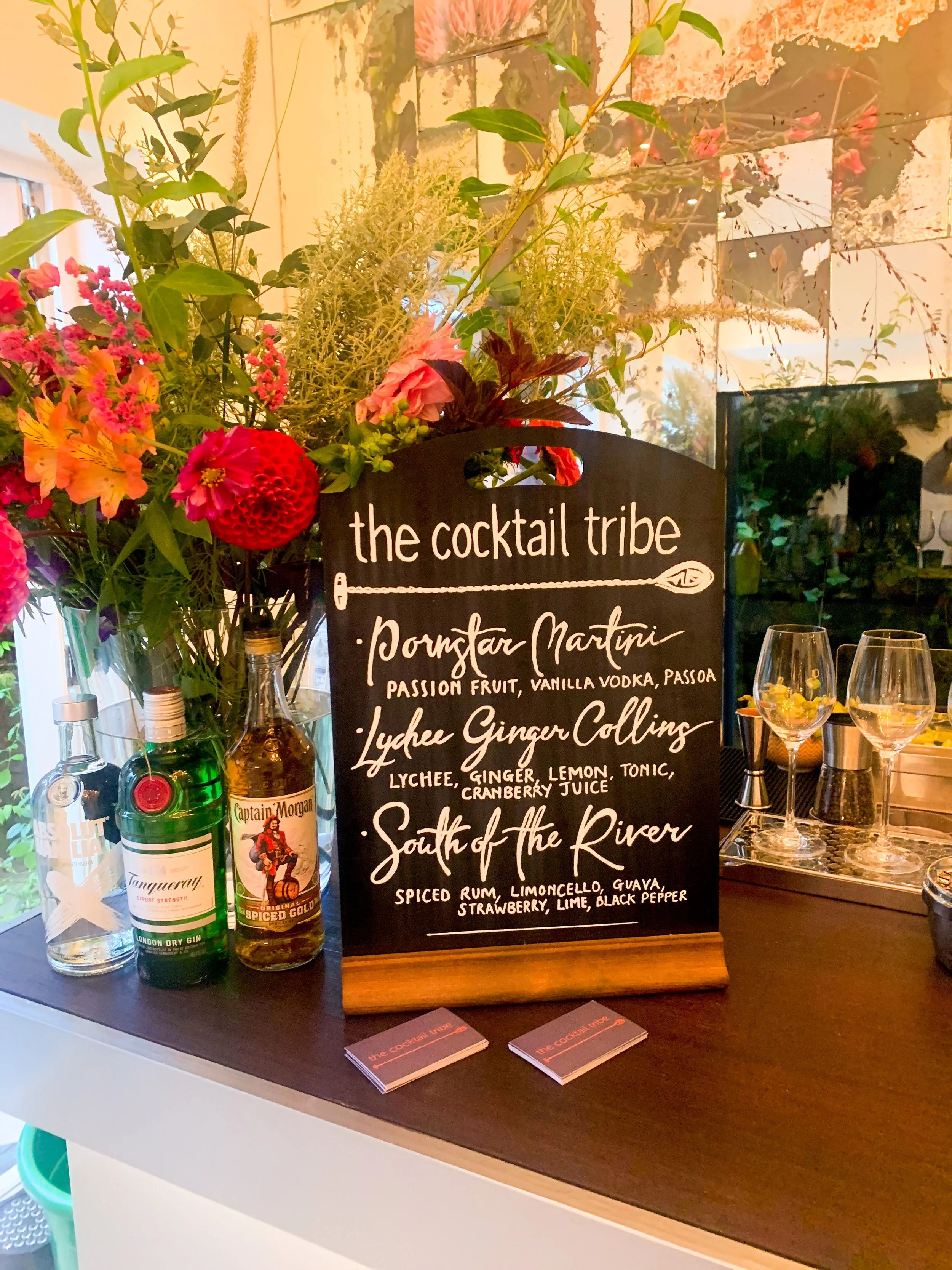A tailored cocktail menu surrounded by colourful flowers for a cocktail party in Brighton, Sussex area