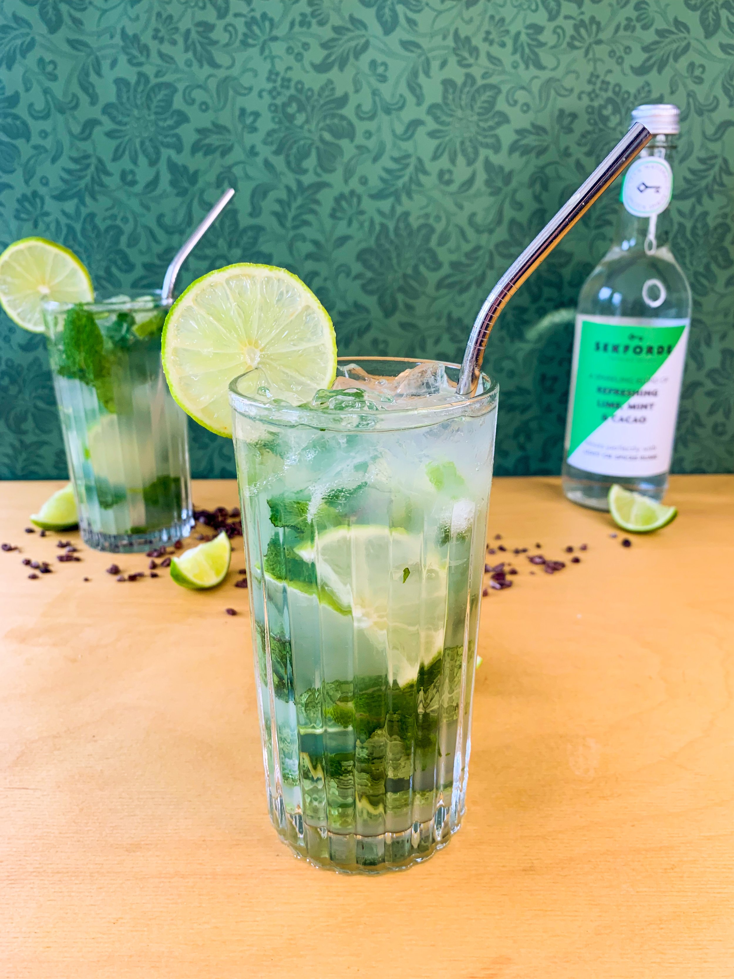 A mojito cocktail served in a highball glass garnished with a lime wheel
