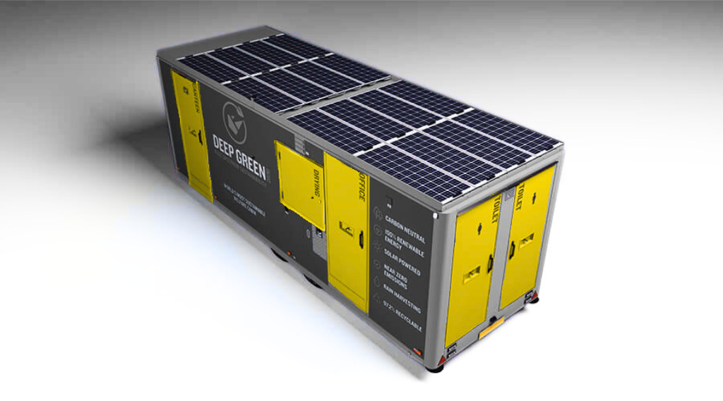 A large mobile container with solar panels on top, labeled with yellow doors and various markings, used for energy storage or renewable energy projects.