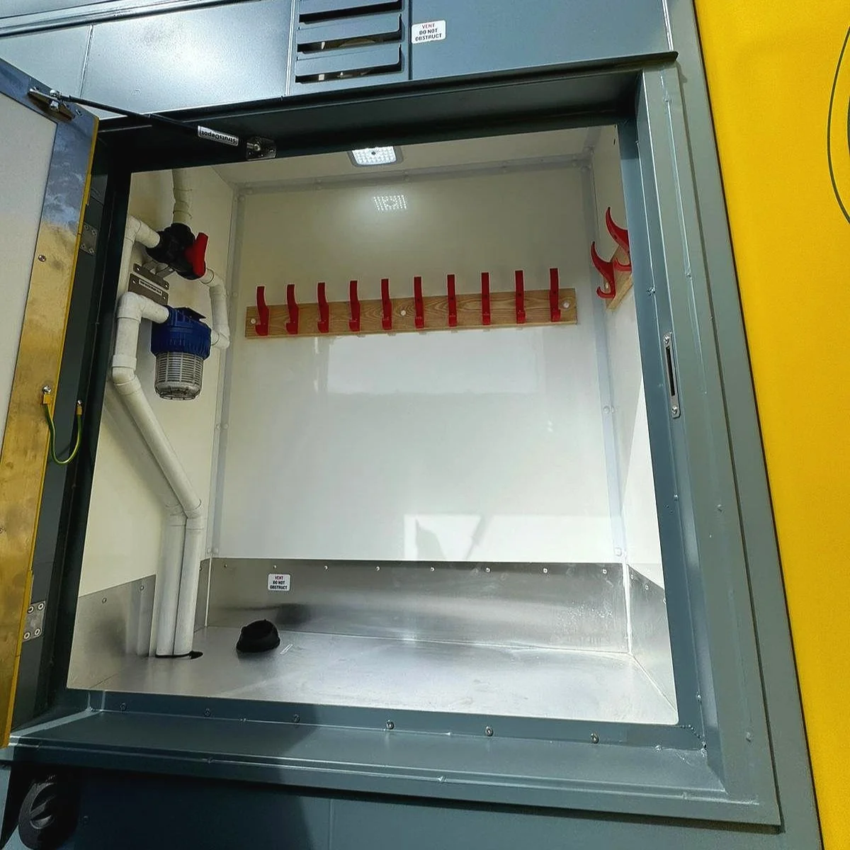 Empty clean fire safety cabinet with hooks and piping, no fire extinguishers or equipment inside.