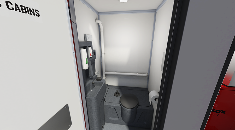 A small, enclosed restroom with a toilet, a toilet paper roll, and a wall-mounted hand sanitizer dispenser.