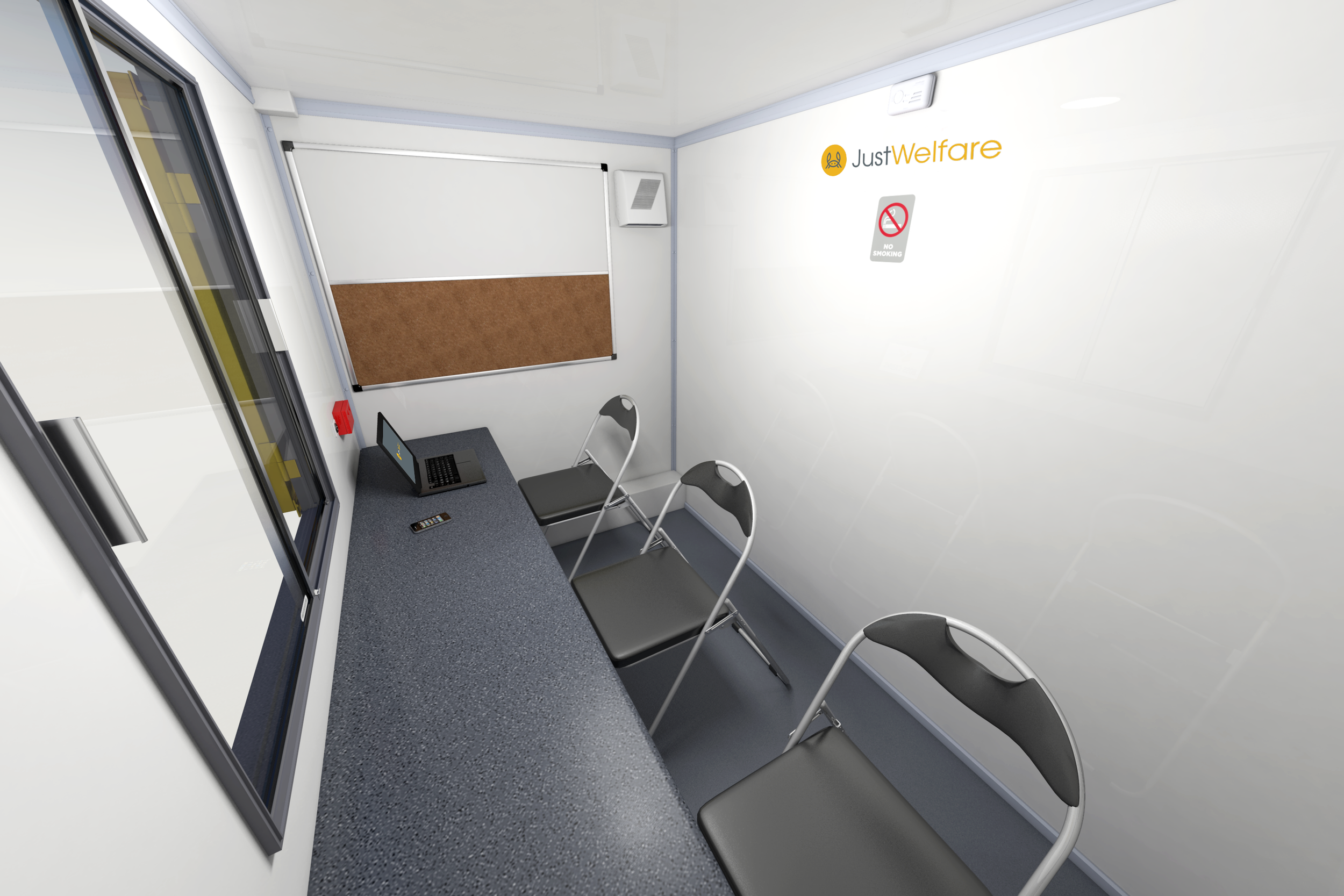 Small office space with a desk, three chairs, a laptop,u a remote control, a window, and a bathroom door with a sign, wall-mounted speaker, and a whiteboard.