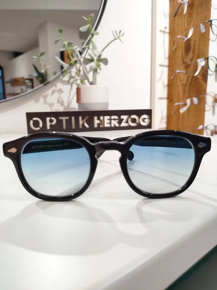 Sonnenbrille vor dem Optik-Herzog-Schriftzug