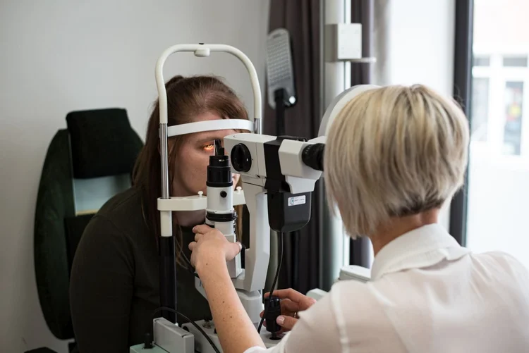 Augenoptikerin bei der Untersuchung am Spaltlampen-Mikroskop