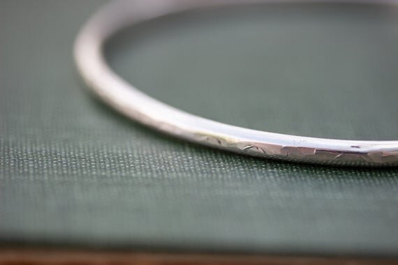 close up of Sterling silver bangle with hammered textured surface