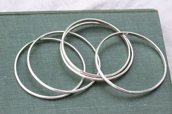 group of slim silver stacking bangles