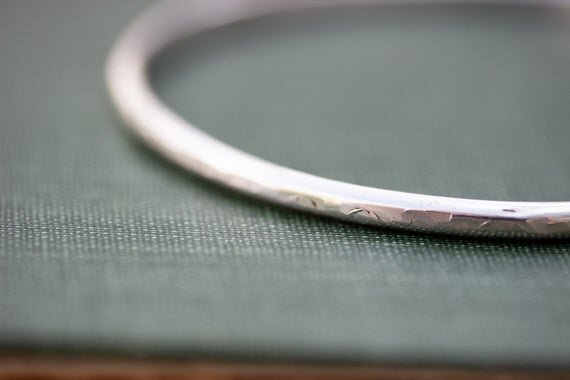close up of handmade silver bangle textured surface
