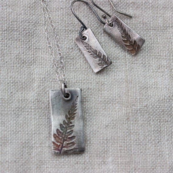 handmade silver pendant necklace and earrings with botanical fern pattern