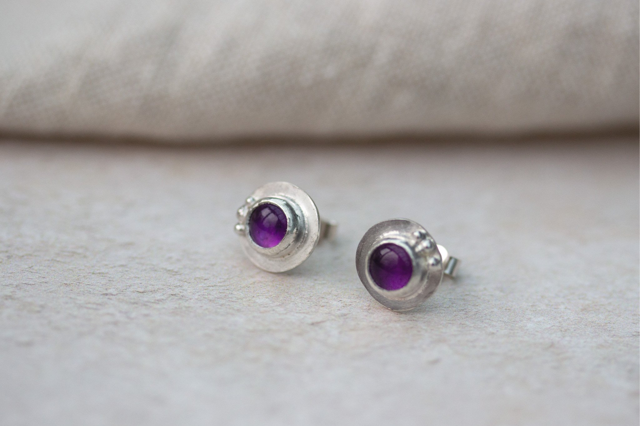 pair of small handmade silver circle studs with purple amethyst semi-precious earrings