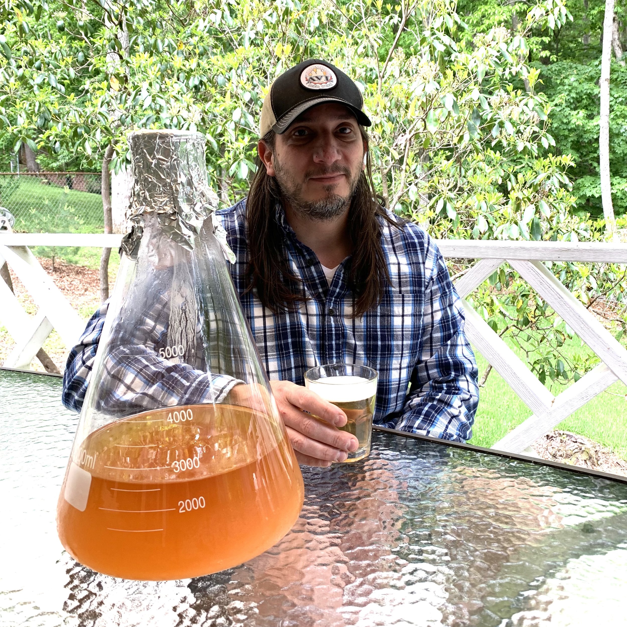  Homebrewer David Maida enjoys the company of a yeast starter culture and a finished lager. Maida partners with specialized yeast strains to brew about a dozen beers a year.  Image credit: Laura Elizabeth Palermo. 