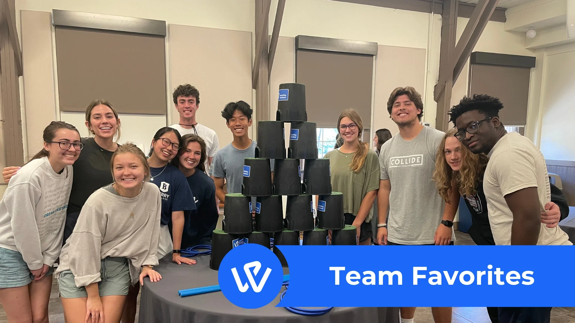 Group of students around buckets stacked in a pyramid at a WorkPlay Solutions teambuilding event