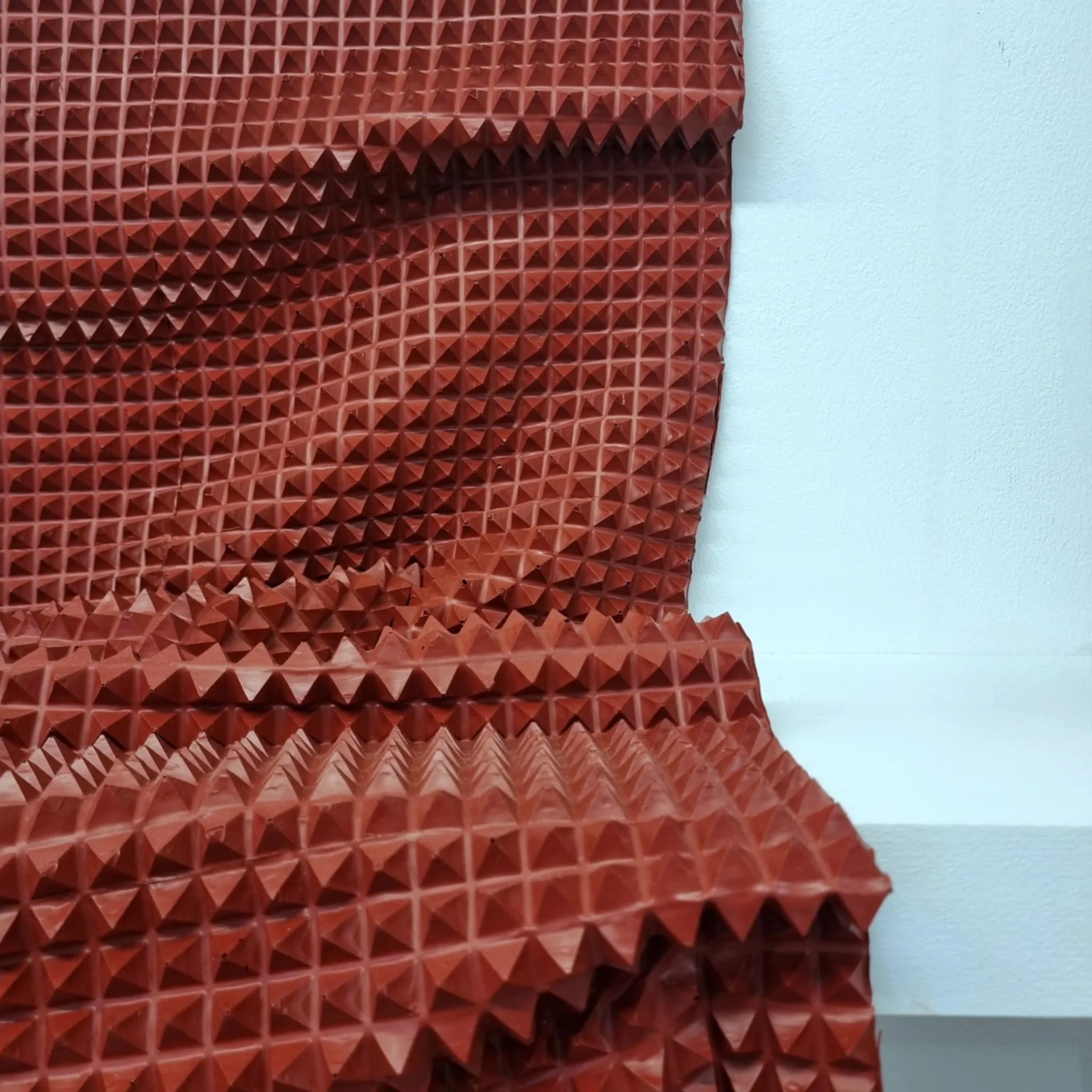 Red gridded sculpture made entirely from dried acrylic paint.