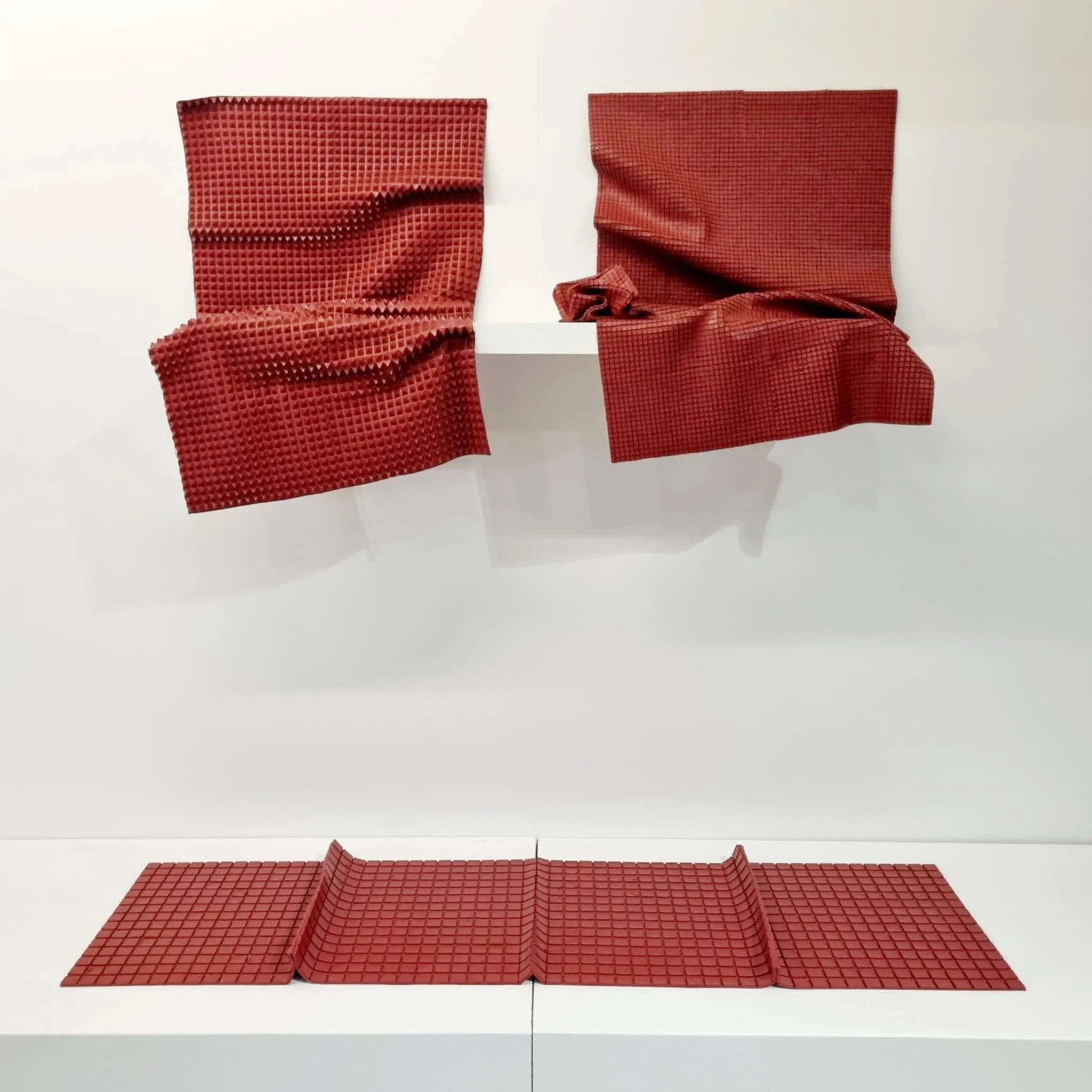 Red gridded sculpture made entirely from dried acrylic paint.