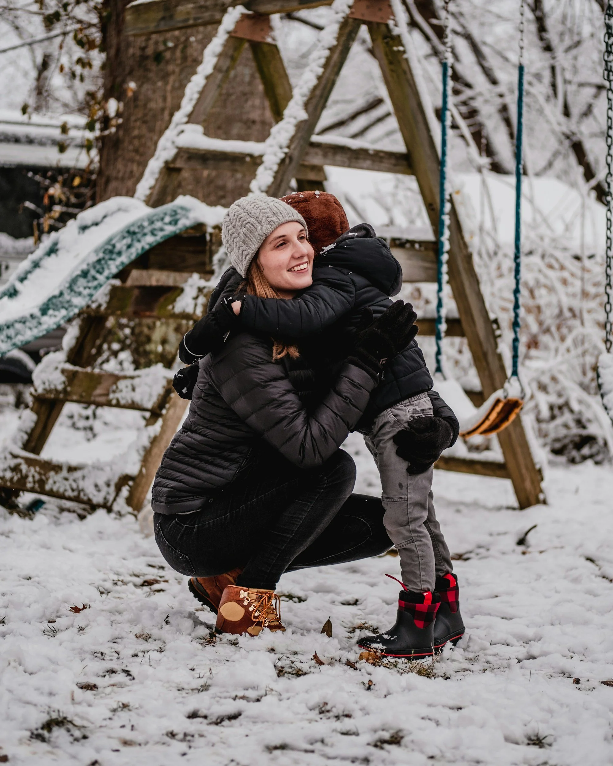 nanny playing with child in snow