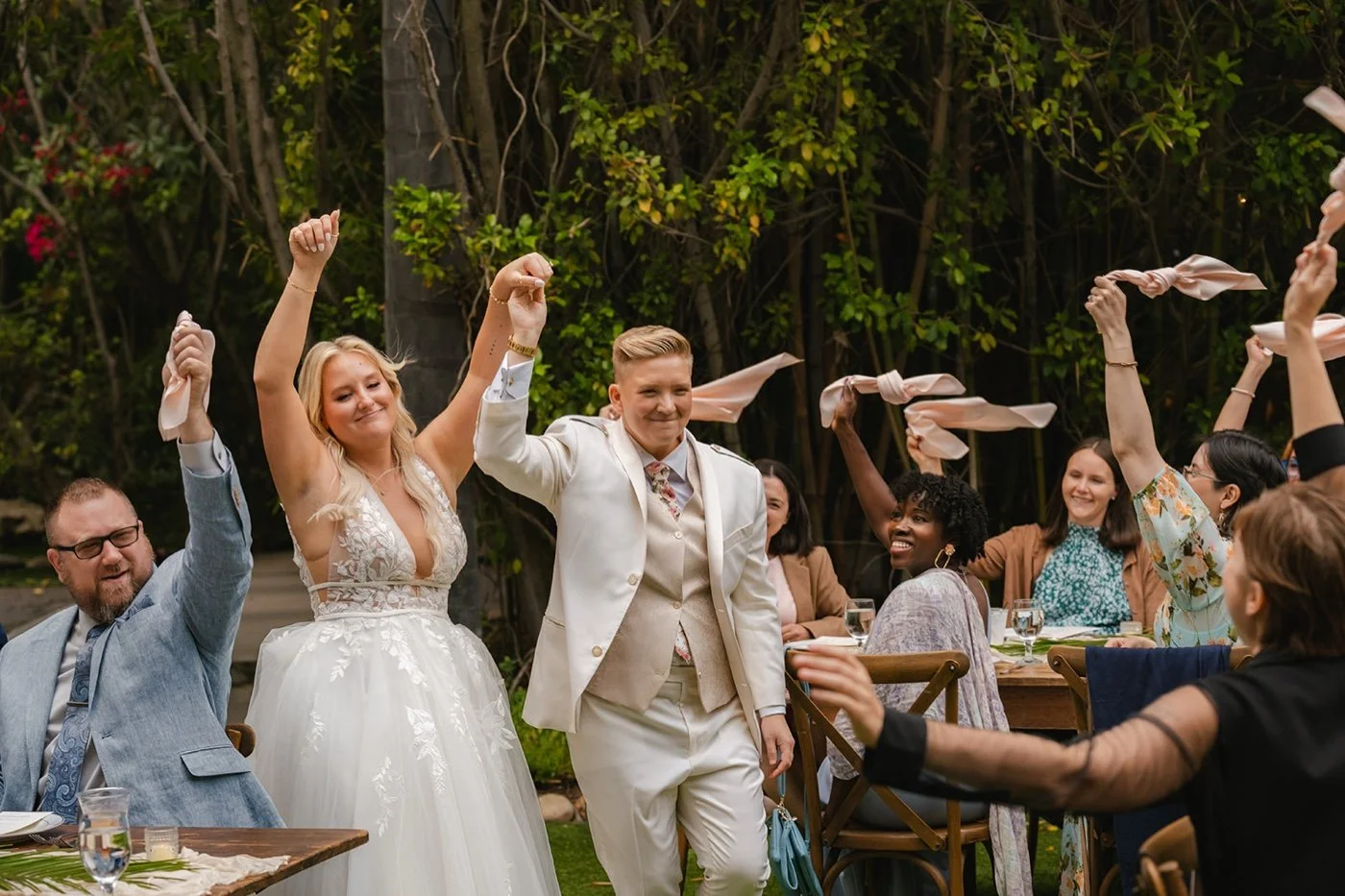 two brides entering their outdoor wedding reception at botanica in oceanside california