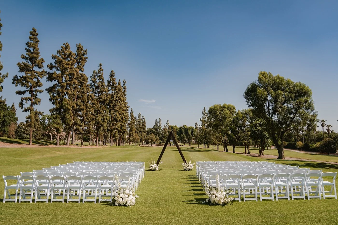 wedding ceremony with white flowers on the glendora country club golf course