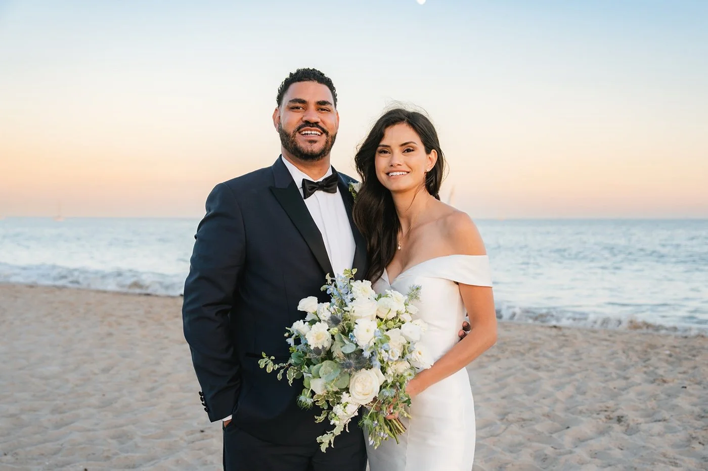 bride and groom taking portraits on the beach at their cabrillo pavilion wedding in santa barbara