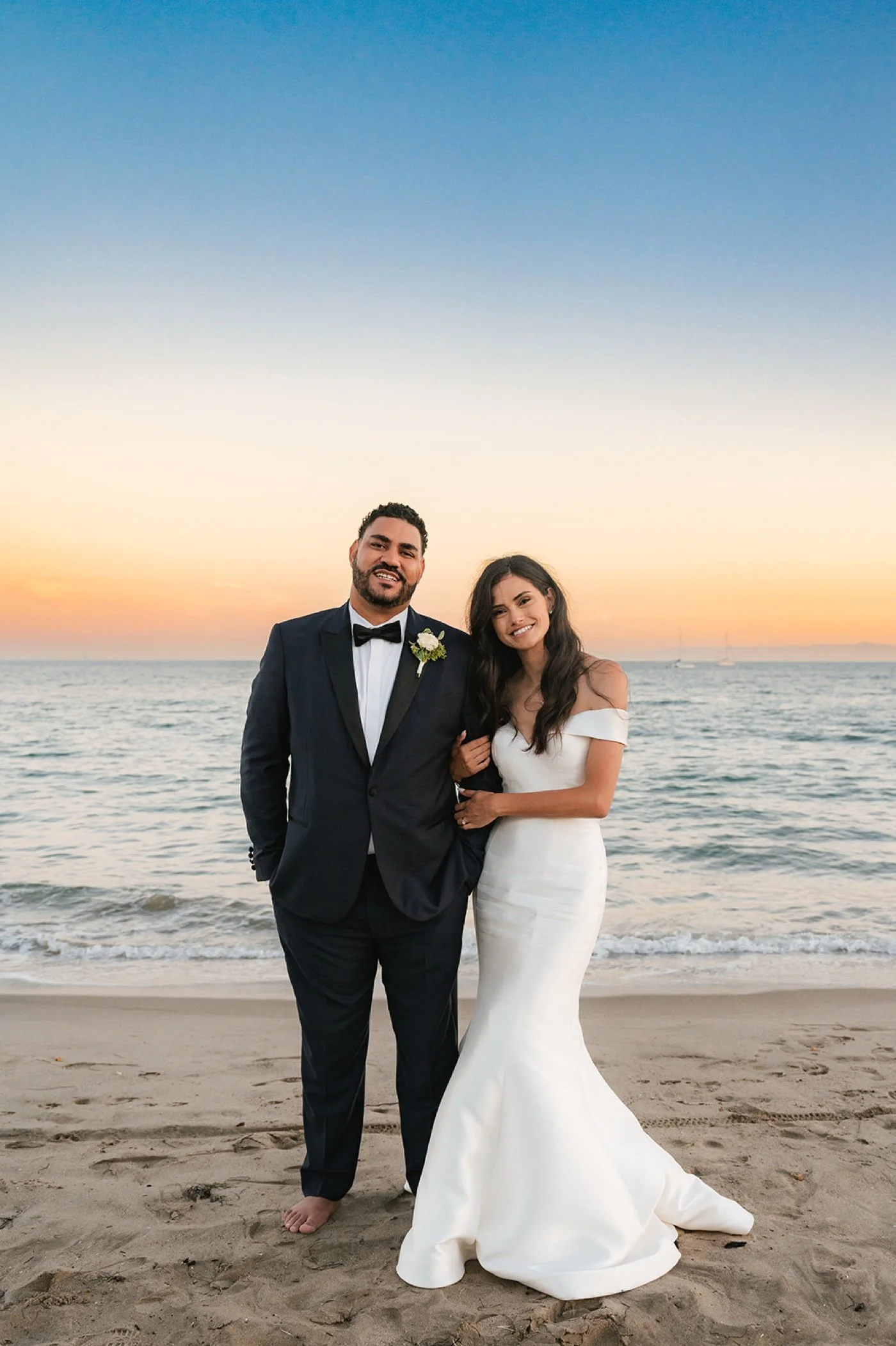 bride and groom taking portraits on the beach at their cabrillo pavilion wedding in santa barbara