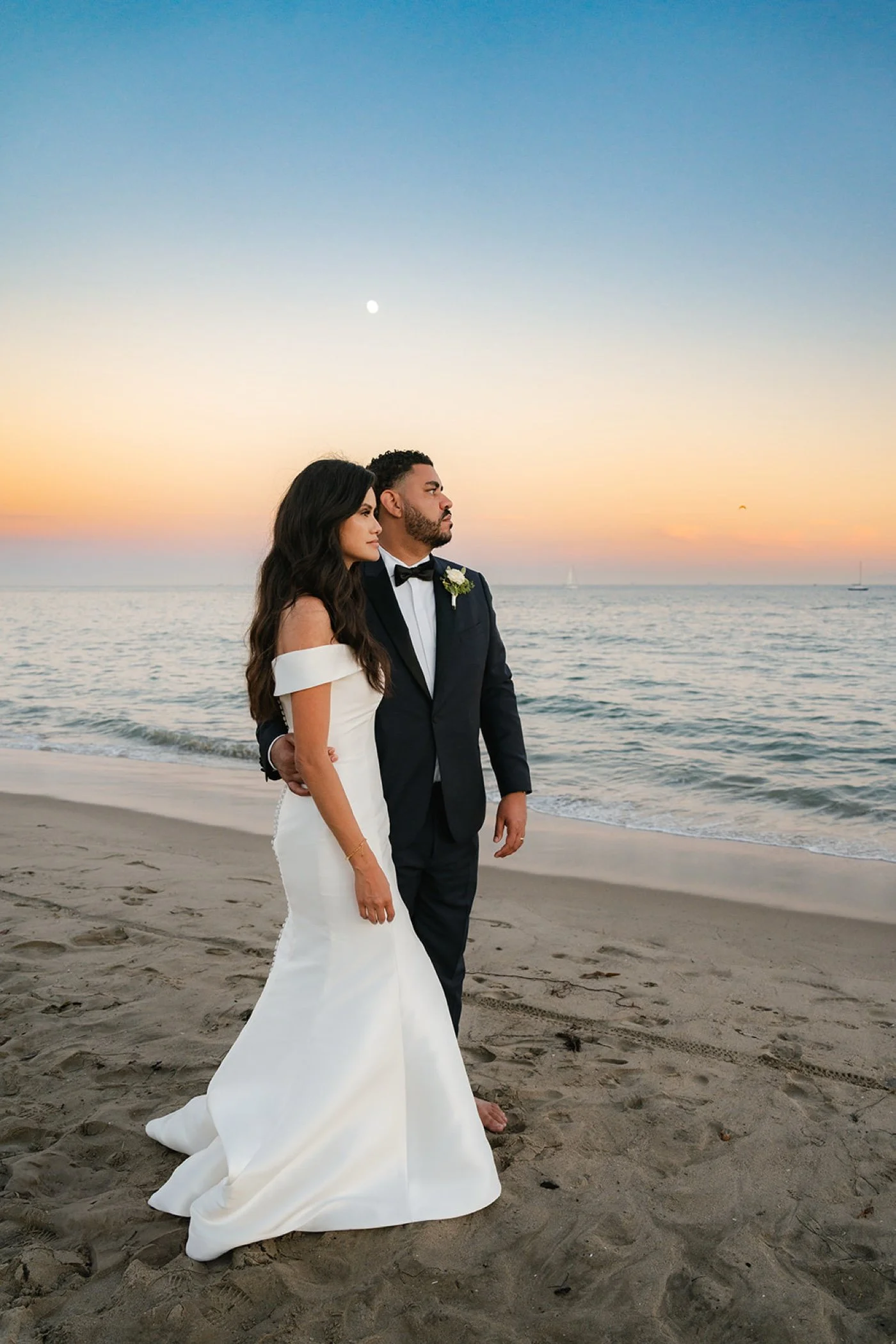 bride and groom taking portraits on the beach at their cabrillo pavilion wedding in santa barbara